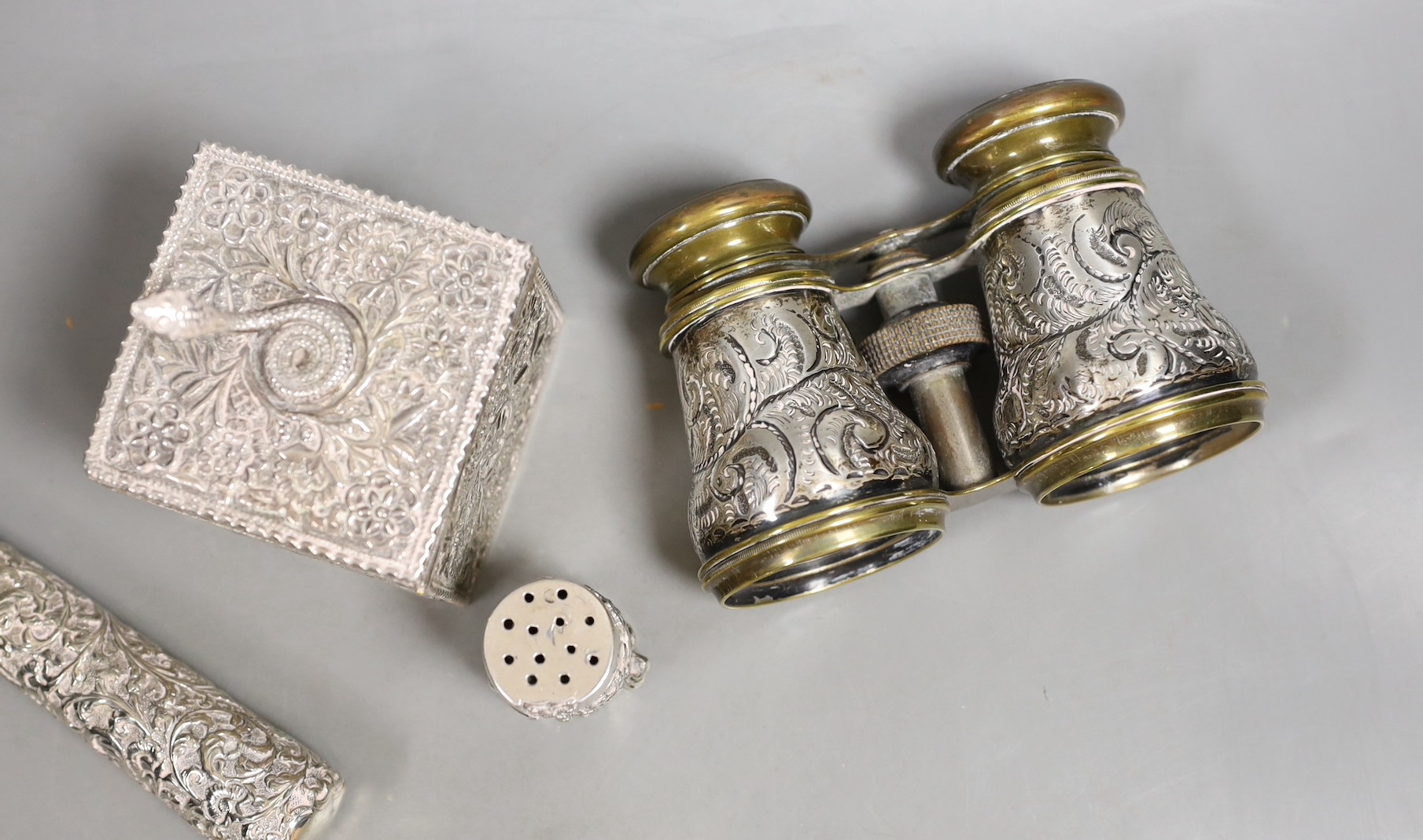 A late Victorian Indian silver box and cover, with serpent finial, import marks for London, 1898, 9cm, a Chinese Export white metal condiment, a pair of late Victorian silver mounted opera glasses and a white metal paras